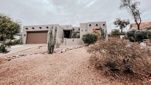 A modern building with a garage, surrounded by cacti and desert plants. - Welcome to Casa Lana !! (Gold Canyon)