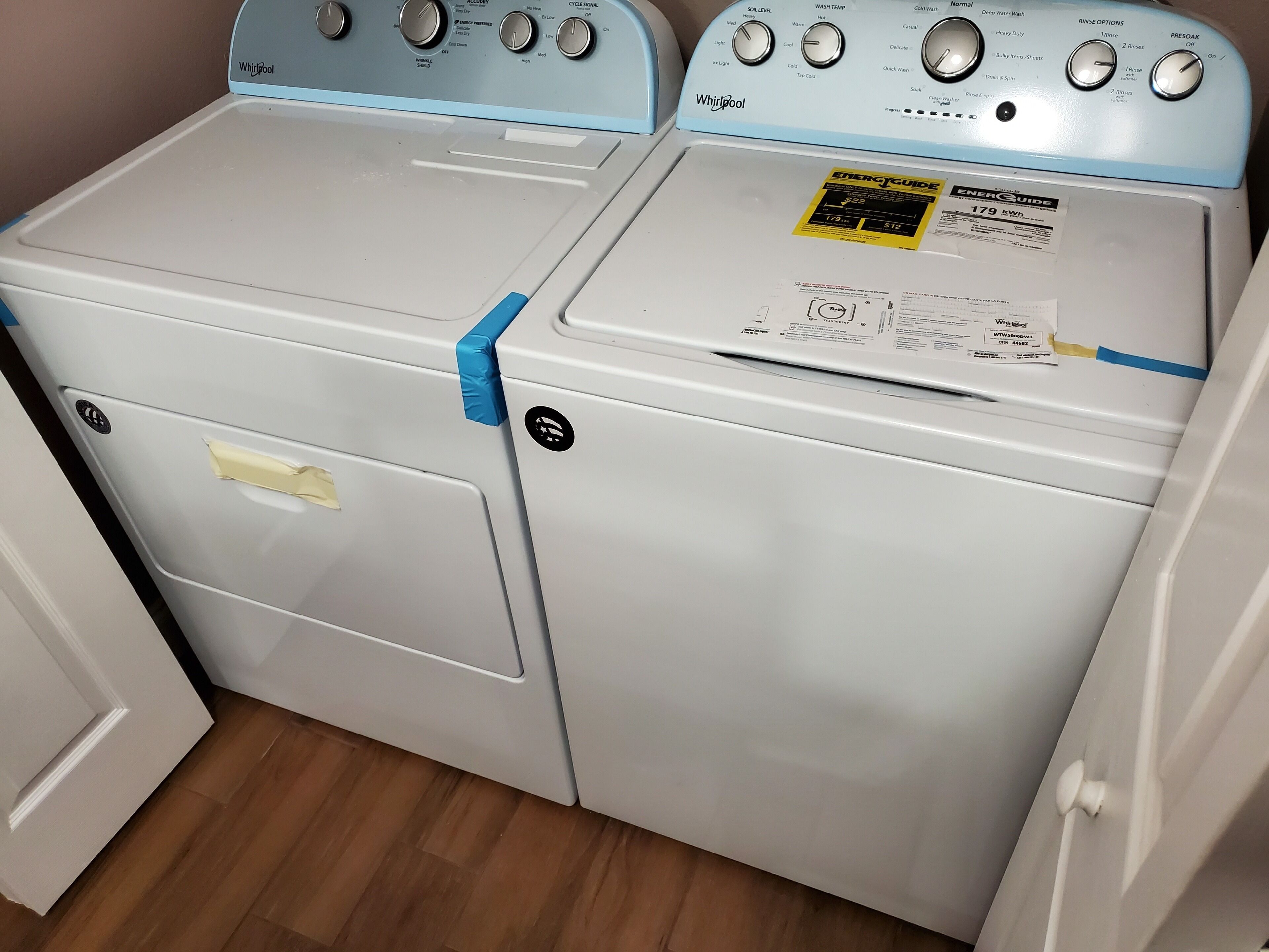 Two stacked washer and dryer units with visible control panels and a label indicating energy consumption.