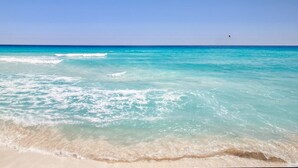 Uma praia com águas turquesa cristalinas e uma orla arenosa.