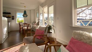 Uma sala de estar ampla, com uma janela grande, uma mesa de jantar e um espaço de estar aconchegante.