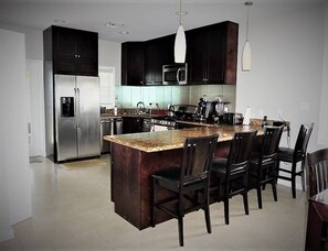 Enjoy cooking in this well-equipped kitchen with a central island, gas stove, and stainless steel appliances.