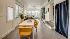 A spacious living area with a dining table and chairs, a sofa, and a TV. - Tropical Oasis Pool Kayak Bikes fish from dock  (Matlacha)
