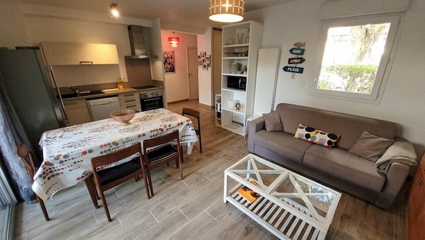 Un espace de vie compact comprenant un coin repas, une kitchenette et un canapé.