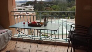 Un balcon avec une table, des chaises et une vue sur le paysage.