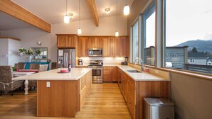A modern kitchen with wooden cabinets, stainless steel appliances, and a large island. - Blackberry Bramble 3 Bedroom Home by RedAwning (Hood River)