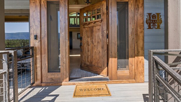 A wooden entrance with a 'WELCOME' mat, a view of the interior, and a 'HOLLAND' sign on the wall. - Luxury Mountain Chalet with Elevator & Hot Tub, Dog Friendly (Durango)