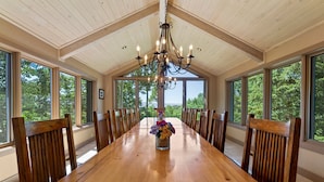 A long wooden dining table with chairs, a chandelier, and a vase of flowers. - Luxury Mountain Chalet with Elevator & Hot Tub, Dog Friendly (Durango)