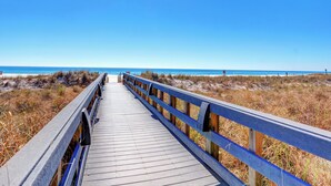 A wooden boardwalk leading to a beach with clear skies. - SeaChase 1601W by Liquid Life (Orange Beach)