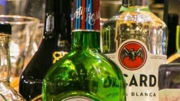 A variety of liquor bottles, including Martini, on a shelf.