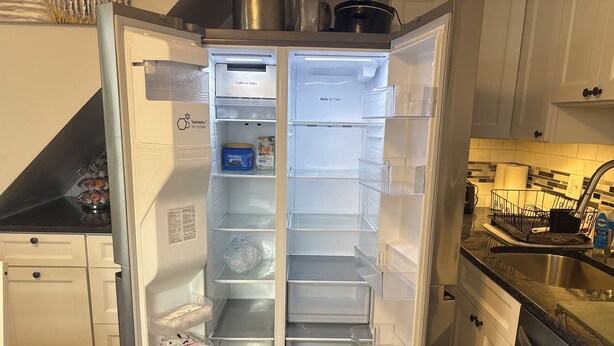 Una cocina moderna con refrigerador empotrado, lavavajillas y pileta.
