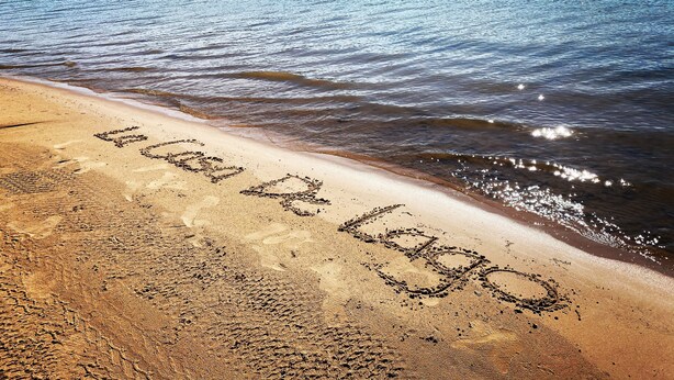 Ein Strand, auf dem der Schriftzug 'Love Lake' im Sand geschrieben steht.