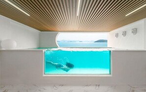 A modern room with a large window, a view of the sea, and a wooden ceiling. - Sugarbrium (Yeosu)