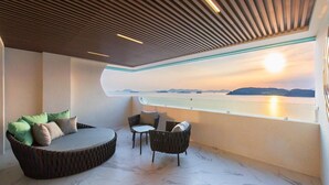Un intérieur moderne avec un espace salon circulaire, deux fauteuils et une grande fenêtre donnant sur une étendue d'eau.