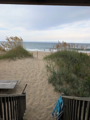 A sandy beach path leading to the ocean with a wooden bench and a blue umbrella. - Beach Retreat - OceanFront Cottage (Kitty Hawk)