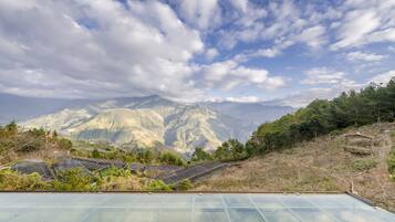 A greenhouse with solar panels and a view of mountains.