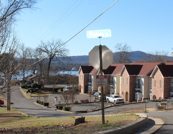 Une rue résidentielle bordée de maisons, avec un panneau de signalisation et un panneau indiquant « Interdiction de stationner les bateaux, les remorques et les camping-cars ».