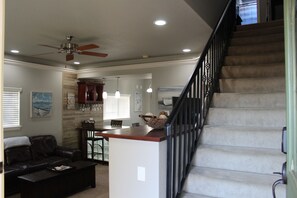 Relax in the living area with a sofa and coffee table, surrounded by a neutral color palette and natural light.