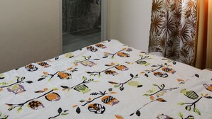 A hotel room with a bed, a bathroom with a sink and mirror, and an air conditioning unit. - Townhome with 24Hr Security in Panglao Island (Dauis)
