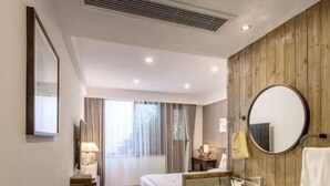 A hotel room with a bed, a round mirror, a sink, and a window with curtains. - Zhenchuang Tingyu Pingjiang Inn No.2 (Suzhou)