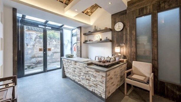 A modern kitchen with a stone island, wooden beams, and a large window. - Zhenchuang Tingyu Pingjiang Inn No.2 (Suzhou)