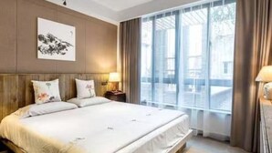 A modern hotel room with a large bed, a nightstand, a lamp, and a window with curtains. - Zhenchuang Tingyu Pingjiang Inn No.2 (Suzhou)