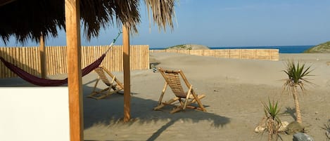 En la playa, sillas reclinables de playa, sombrillas