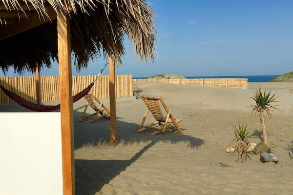 A la platja, gandules de platja i para-sols per a la platja