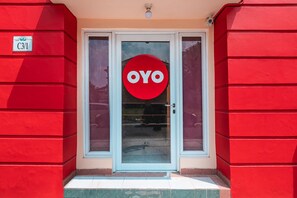 A red building with a glass door and a sign that reads "OYO". - OYO 1554 Pavilio  Residence (Cikarang)