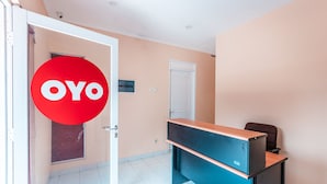 A room with a desk, a chair, and a door. - OYO 1554 Pavilio  Residence (Cikarang)