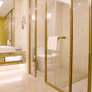 A modern bathroom with a glass-enclosed shower, a vanity with a mirror, and a toilet.