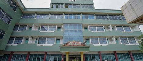 A multi-story hotel with a central entrance, several windows, and a sign indicating it is a hotel and restaurant.