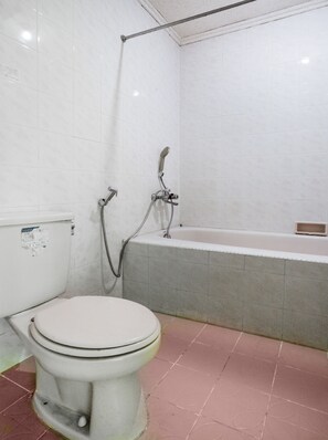 Ein Badezimmer mit Toilette, Dusche und Badewanne.