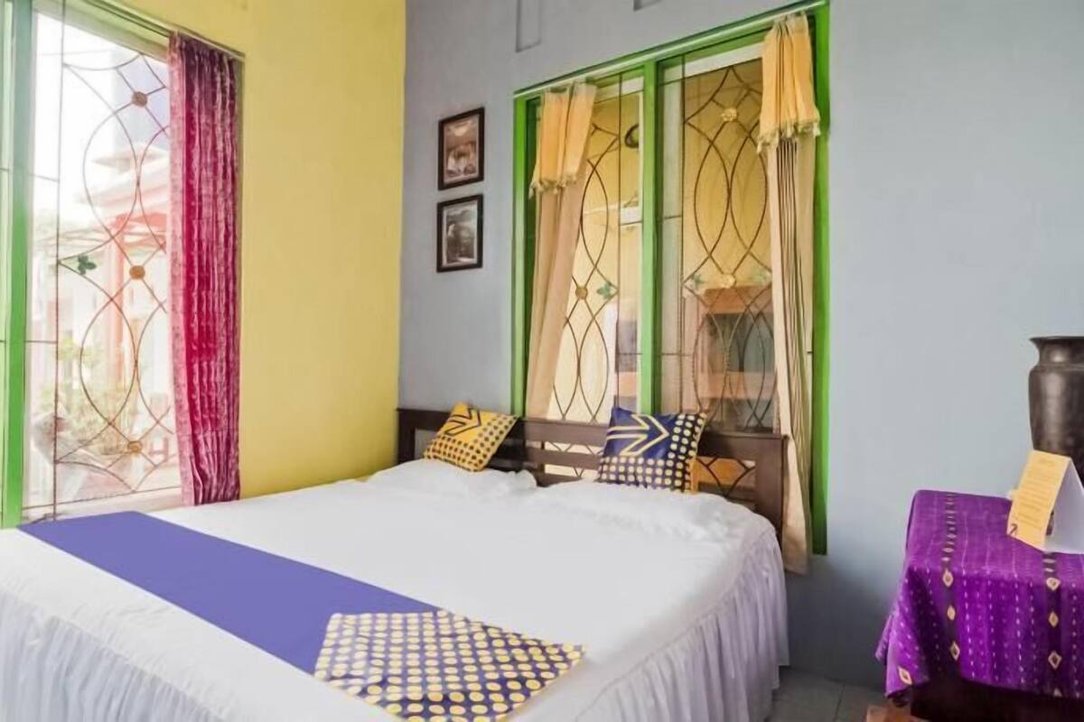 A room with a bed, a table, and curtains.