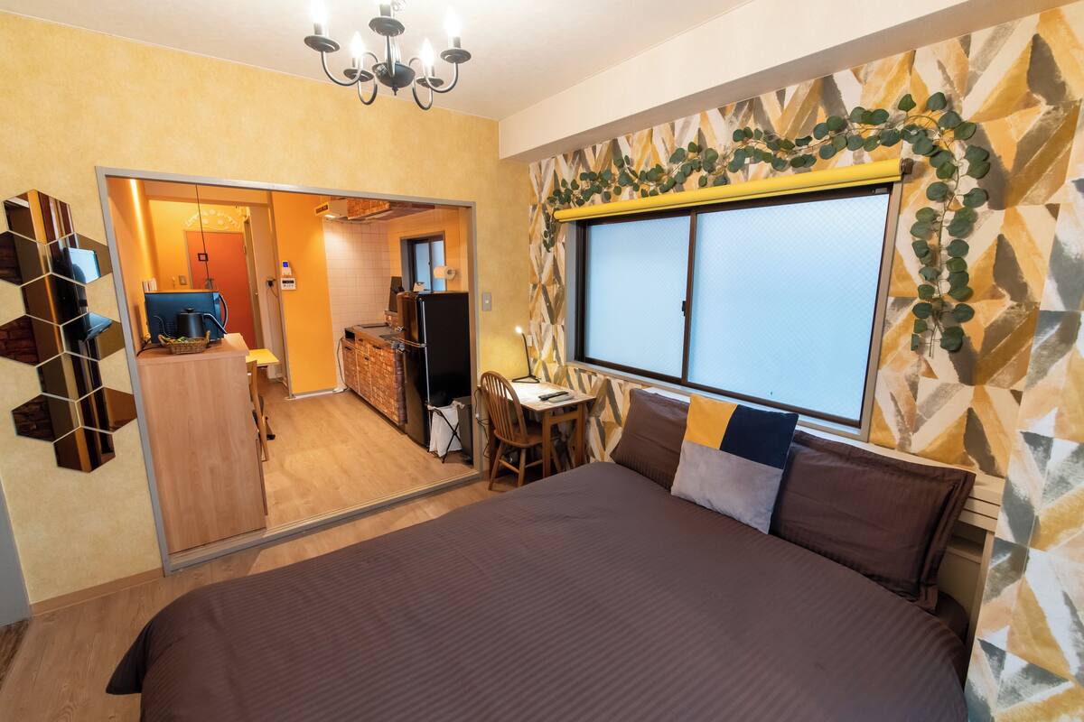 Un dormitorio con una cama grande, un escritorio y una ventana con vistas.