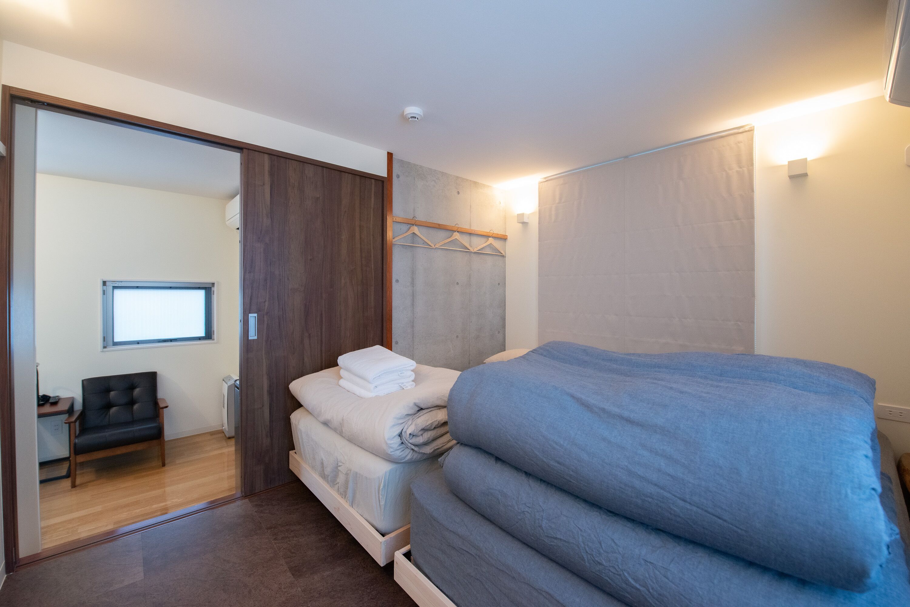 Une chambre à coucher avec un lit, une chaise, un bureau et une armoire.