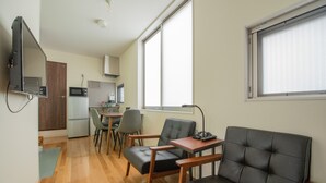 Ein kompakter Wohnraum mit Küchenzeile, Essbereich und einer Sitzecke mit Fernseher.