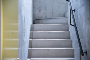 A concrete staircase with metal handrails, leading to an upper floor. - bmj Hyakunincho (Tokyo)