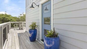 A wooden deck with two large blue planters, a blue door, and two wall-mounted lights. - Gulf and State Park Views, Private Beach, HOT TUB (Santa Rosa Beach)