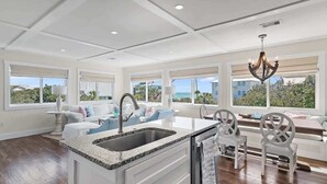 A spacious kitchen with a large island, white cabinetry, and a view of the ocean. - Gulf and State Park Views, Private Beach, HOT TUB (Santa Rosa Beach)