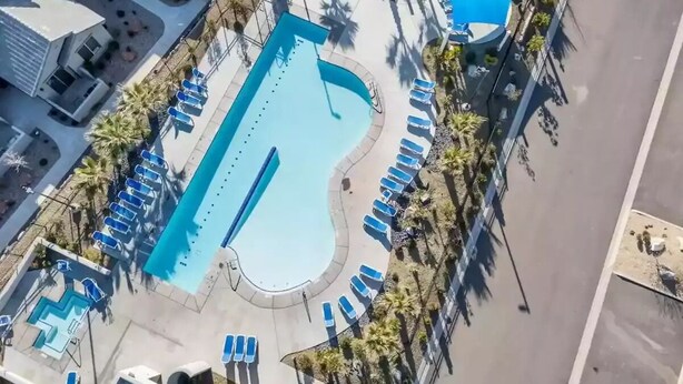 An aerial view of a swimming pool with sun loungers, surrounded by palm trees and a blue canopy. - Poolside Adventures: FREE State and National Parks Passes! (Washington)