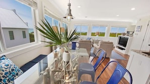 A modern kitchen with a dining area, large windows, and a view of the landscape. - 30A Beachfront and State Park Views, Gulf Trace (Santa Rosa Beach)