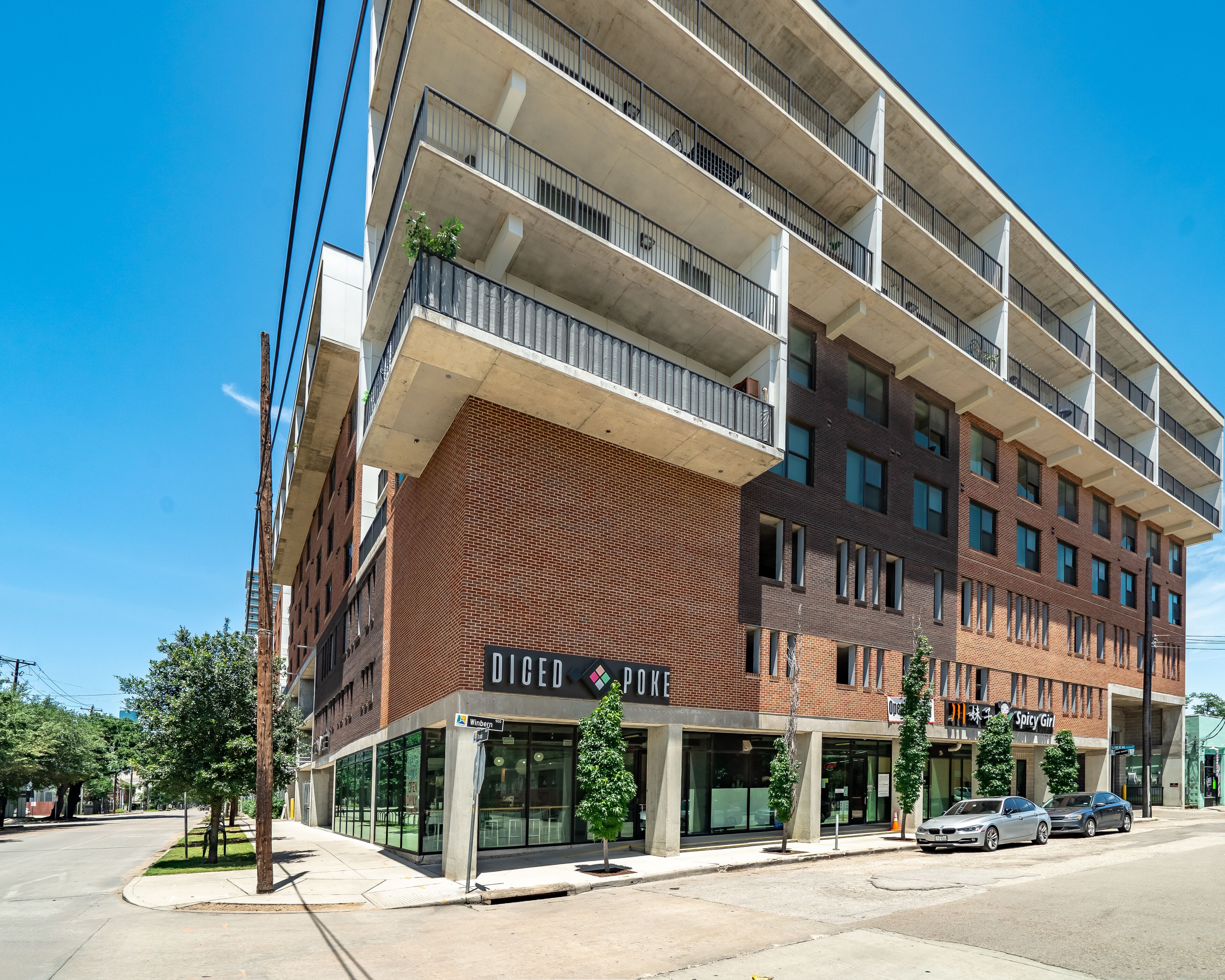 A multi-story building with a brick facade and balconies.