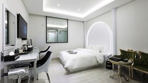 A modern hotel room with a bed, a desk with a computer, a chair, a vanity with a mirror, and a TV. - Gwangmyeong W Hotel (Gwangmyeong)