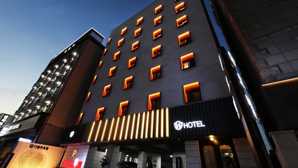 A modern hotel with a dark facade and illuminated windows. - Gwangmyeong W Hotel (Gwangmyeong)