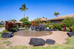 Surrounded by lush tropical plants and a tranquil pond, this serene oasis offers a peaceful escape.