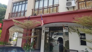Ein Hotel mit roter Fassade, mehreren Balkonen und Klimaanlagen.
