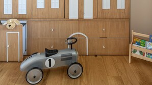 A room with wooden wardrobe doors, a toy car, and a small shelf with books. - Old North Hidden Treasure 2BR 2BA (Tel Aviv)
