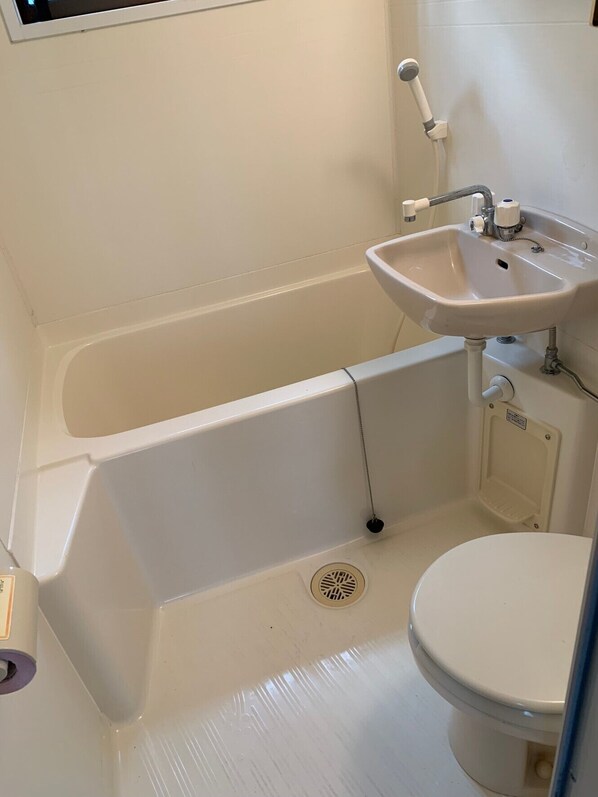 A bathroom with a bathtub, sink, and toilet.