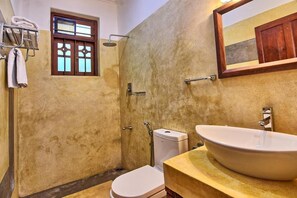 A bathroom with a large sink, a toilet, a shower, and a window. - Ali Gedara Bungalow (Galle)