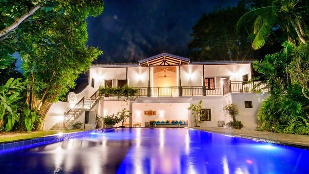 A modern building with a swimming pool, surrounded by lush greenery. - Ali Gedara Bungalow (Galle)